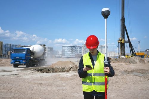 Arpenteur-géomètre analysant des données sur un chantier de construction