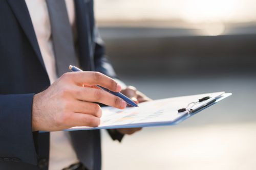 Homme listant ses biens sur un bloc-notes