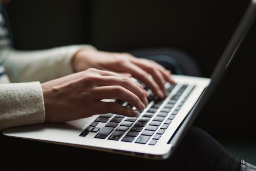 Personne écrivant son inventaire de biens sur un ordinateur portable