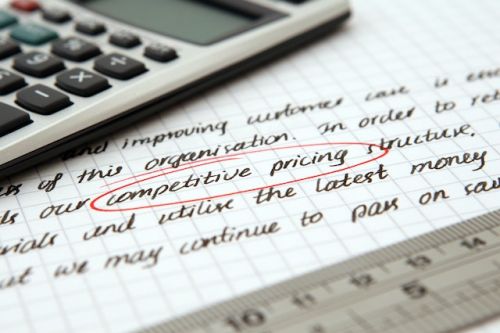 Prix compétitif entouré sur une feuille avec calculatrice