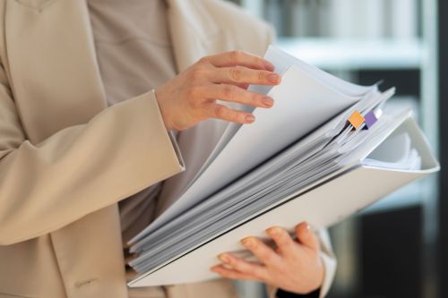 Courtière immobilière tenant une pile de documents
