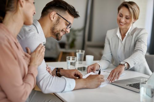Couple de futurs mariés signant un contrat de mariage devant une notaire
