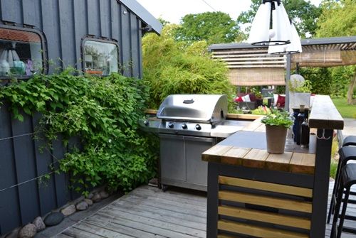 Petite cuisine extérieure avec comptoir en bois et barbecue
