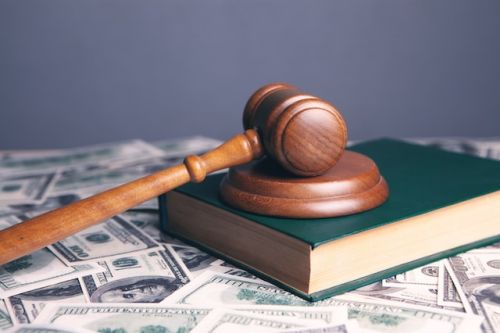 Code civil et marteau de juge sur des billets d’argent 