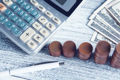 Calculatrice, argent et crayon sur une table