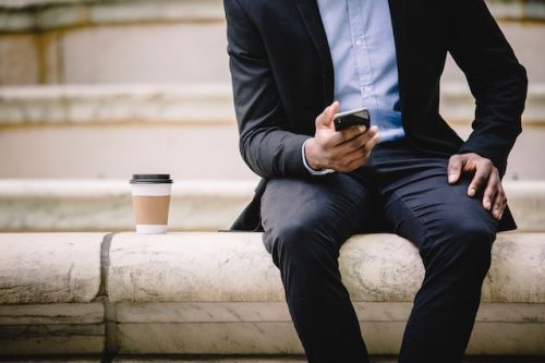 Homme d’affaires assis avec son téléphone