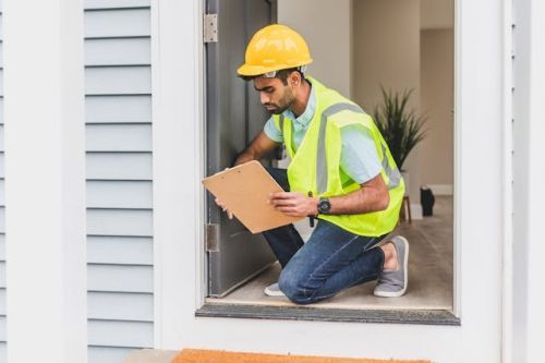 Building inspector inspecting the door of a house