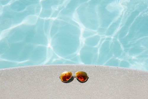 Lunettes de soleil à côté d’une piscine creusée