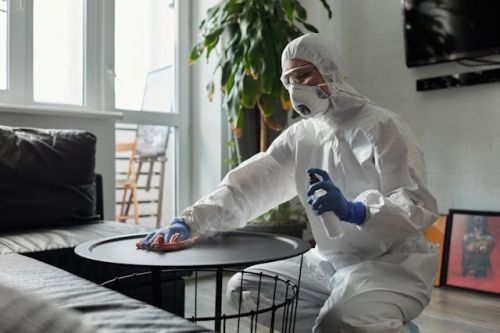 Nettoyeur spécialisé en sinistre désinfectant une table basse