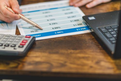 Courtier hypothécaire pointant le taux d'intérêt du jour avec un stylo
